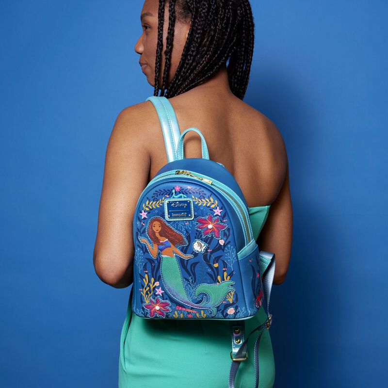 Woman wearing The Little Mermaid Live Action Mini Backpack against a blue background